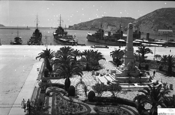 Puerto de Cartagena con buques de guerra fondeados y el monumento a los Héroes de Cavite en primer plano